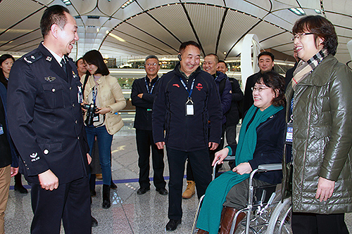 图为张海迪与机场工作人员交谈